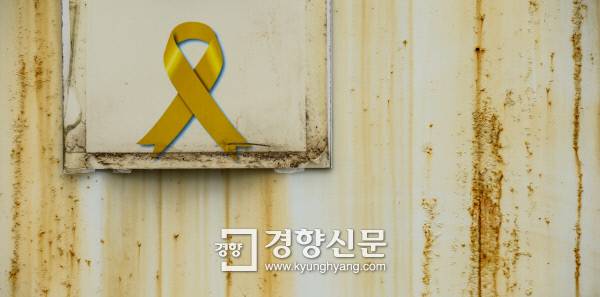 기다림의 흔적 노란 리본 스티커가 붙은 전남 진도군 팽목항의 컨테이너 숙소 외벽이 녹슬어가고 있다. 9명의 세월호 미수습자 가족들이 이곳에 머물며 1000일이 다 되도록 피 말리는 기다림을 이어가고 있다. 이준헌 기자 ifwedont@kyunghyang.com
