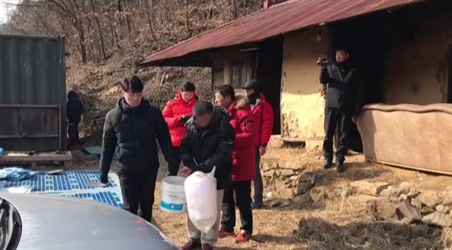 이혼 소송 중이던 아내를 살해한 뒤 시신을 불에 태워 유기한 한모(52)씨가 17일 강원 홍천군의 한 빈집에서 현장검증을 하고 있다. 춘천경찰서 제공