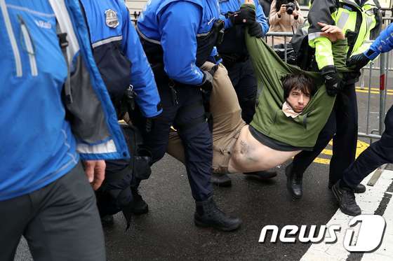 20일(현지시간) 미국 워싱턴D.C 워싱턴D.C 내셔널몰 인근에서 반(反) 도널드 트럼프 시위자가 경찰에 의해 끌려나가고 있다. © AFP=뉴스1