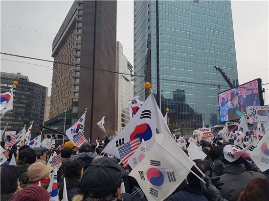 21일 서울시청 앞 대한문에서 열린 10차 태극기집회에서 참가자들이 태극기와 성조기를 흔들고 있다.