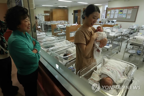 서울의 한 병원 신생아실에서 가족들이 신생아를 바라보는 모습. [사진은 기사 내용과 직접적인 연관은 없음]