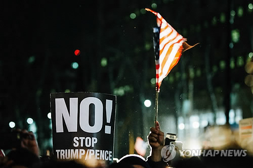 (뉴욕 EPA=연합뉴스) 2일(현지시간) 미국 뉴욕시 브루클린에서 성조기와 피켓을 든 시위자들이 트럼프 대통령의 '反이민' 행정명령을 비난하고 있다.