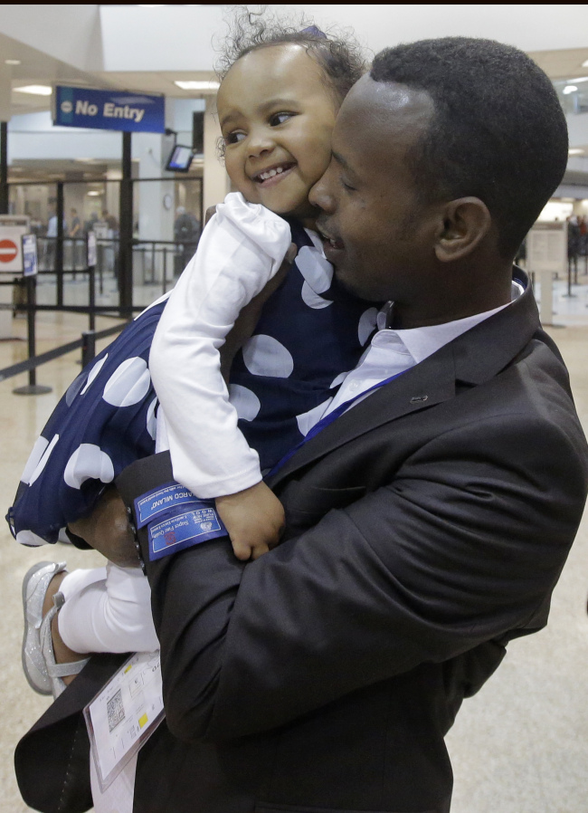 미국 도널드 트럼프 대통령의 반(反) 이민 행정명령으로 발이 묶여 있었던 한 소말리아 난민이 지난 10일(현지시간) 미 유타주 솔트레이크시티 솔트레이크국제공항에 도착해 마중 나온 어린 딸을 껴안고 기뻐하고 있다.[사진=AP연합]