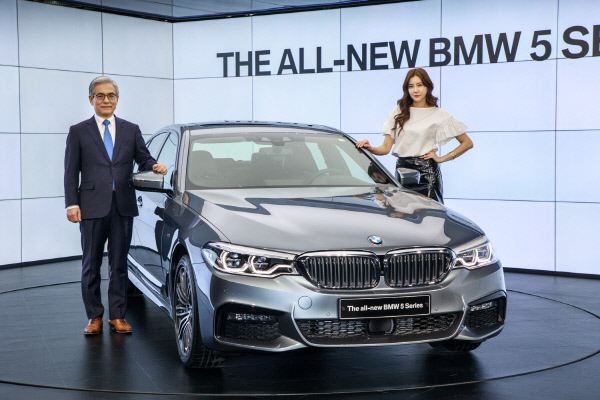김효준 BMW 그룹 코리아 사장(왼쪽)이 21일 뉴 5시리즈 출시 행사에서 모델과 함께 포즈를 취하고 있다.BMW 제공