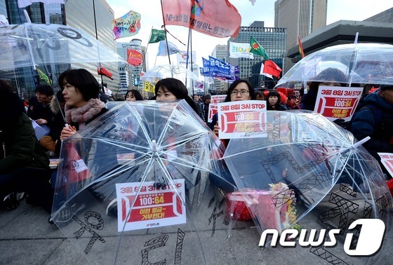 109주년 세계여성의 날을 맞아 8일 오후 서울 광화문 광장에서 열린 ‘조기퇴근 3시 STOP’ 여성연맹여성노동자대회에서 참석자들이 손팻말을 들고 자리에 앉아 있다. 2017.3.8/뉴스1 © News1 박정호 기자