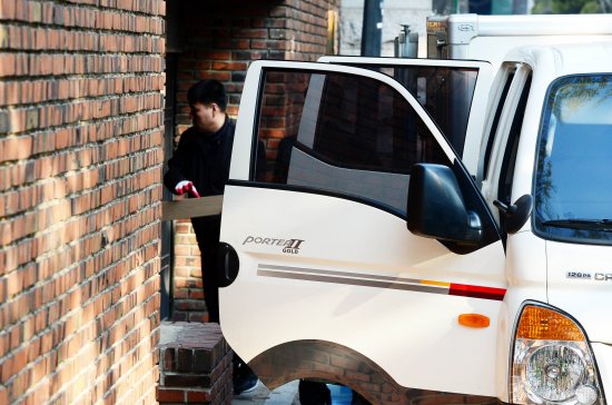 13일 오전 서울 삼성동 박 전 대통령 사저 앞에 세워진 트럭에서 가구들이 들어가고 있다. 뉴시스