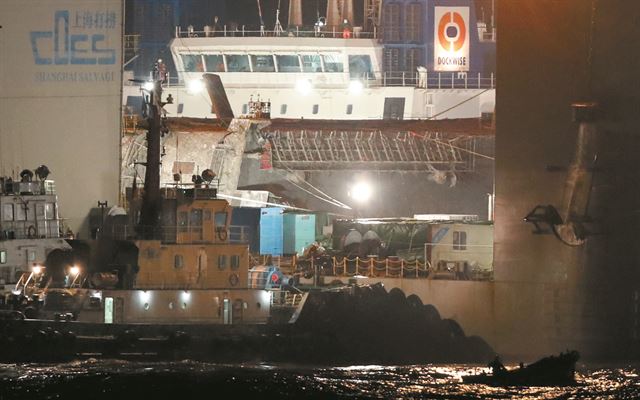 24일 밤 세월호를 반잠수식 선박에 싣는 작업이 진행되고 있다. 연합뉴스