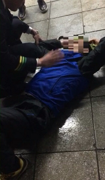 5일 지하철 1호선에서 20대 여성을 성추행하던 한 남성이 구로역에서 코레일 직원에게 연행된 후 바닥에 드러누워 있다. /독자제공