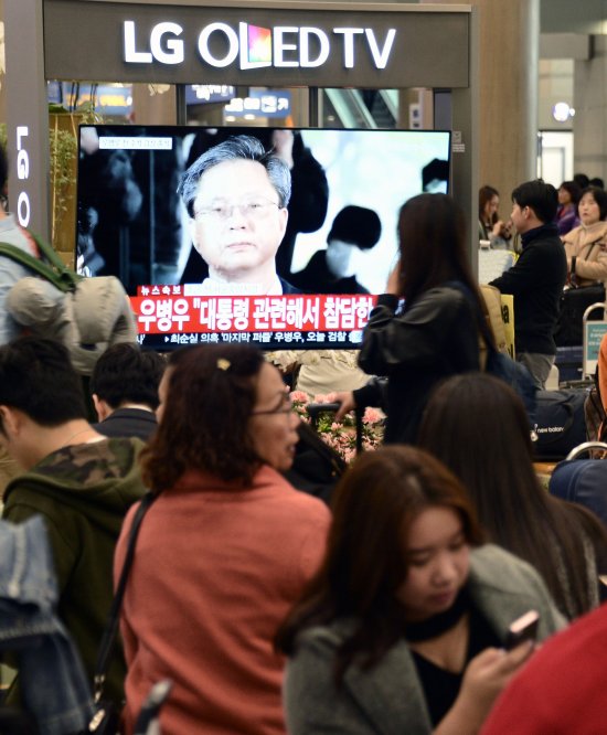 6일 오전 인천공항에서 시민들이 검찰에 소환된 우병우 전 청와대 민정수석의 모습을 TV로 시청하고 있다.  뉴시스