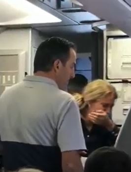 아메리칸항공 여객기에 탑승한 한 아기 엄마가 승무원에게 유모차를 뺏긴 뒤 흐느껴 울고 있다 <유튜브 영상 캡처>