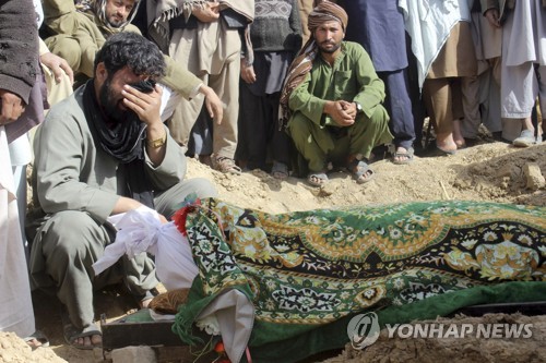 지난해 11월 아프가니스탄 쿤두즈 주의 한 마을에서 탈레반과 정부군의 충돌 와중에 숨진 희생자 주변에 주민들이 모여 있다.[AP=연합뉴스 자료사진]
