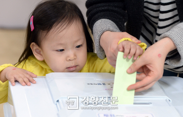 제20대 국회의원선거 투표일인 지난해 4월 13일 서울 천연동 주민센터에 마련된 투표소에서 엄마와 함께 온 어린이가 투표용지를 넣고 있다. /김정근기자