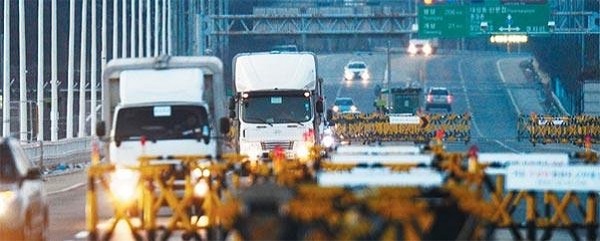 ▶2016년 1월 북한의 핵실험으로 개성공단을 떠난 차량들이 경기도 파주 통일대교를 건너오고 있는 모습./조선DB