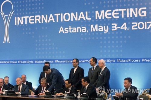 러시아, 이란, 터키 대표가 4일(현지시간) 카자흐스탄 아스타나에서 시리아 '안정화 지역'(De-escalation areas) 설치 협약서에 서명하고 있다. [AFP=연합뉴스]