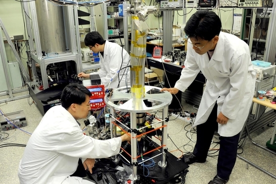 표준과학연구원 연구자들이 세슘 원자시계를 살펴보고 있다./표준연 제공