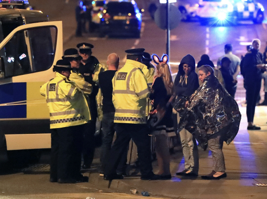 ‘공포’ : 22일 폭탄 테러가 발생한 영국 맨체스터 아레나 앞에서 경찰들이 아레나 밖으로 빠져나온 사람들을 대상으로 사건 발생 당시 상황과 거동이 수상한 용의자 목격 여부 등에 대한 탐문조사를 하고 있다. 이날 테러로 최소 19명이 사망하고 50여 명이 부상을 입었다.  AP연합뉴스