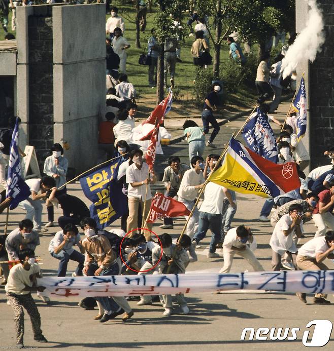 1987년 시위 도중 경찰이 쏜 최루탄에 맞고 쓰러져 숨진 이한열 열사의 모습이 담긴 사진 2점이 공개됐다. 당시 내셔널지오그래픽 사진기자로 한국을 찾은 네이션 벤은 6월 민주항쟁 30주년을 맞아 이한열기념사업회에 이 사진을 제공했다. 사진은 1987년 6월 9일 서울 연세대학교 정문에서 경영학과 2학년생이었던 이한열 열사(현수막뒤 영문자로 ‘연세’라고 적힌 티셔츠와 파란마스크를 착용)가 피격되기 직전의 모습. (네이션 벤 제공) 2017.5.20/뉴스1