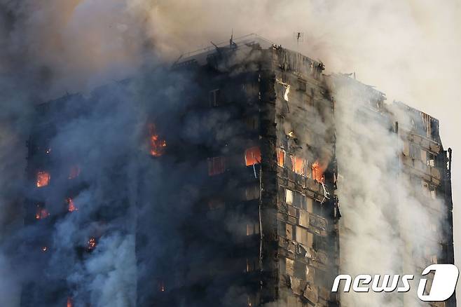 14일(현지시간) 영국 런던에 있는 24층짜리 아파트 건물 그렌펠 타워에서 검은 연기가 솟아 오르고 있다.  © AFP=뉴스1