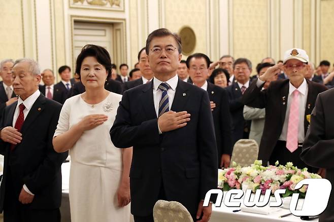 문재인 대통령이 부인 김정숙 여사와 함께 15일 청와대에서 열린 국가유공자 및 보훈가족과의 따뜻한 오찬 행사에서 국기에 대한 경례를 하고 있다. (청와대) 2017.6.15/뉴스1 © News1 이광호 기자