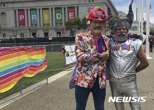 【샌프라시스코 = AP/뉴시스】 미국 샌프란시스코에서 25일 열린 동성애 축제의 게이 프라이드행진에 참가한 폴 브래들리(왼쪽)와 프랭크 레이에스가 포즈를 취하고 있다.   이들은 트럼프정부의 정책에 항의하기 위해 몇년 만에 처음으로 행진에 나왔다고 말했다.2017.06.26