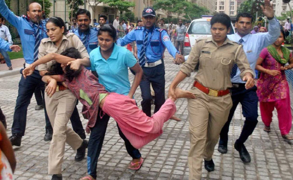 인도 뉴델리 외곽 노이다의 고급아파트 단지 ‘마하군 모던 콤플렉스’에서 지난 12일(현지시간) 가사도우미를 도둑으로 몬 집주인에게 항의하기 위해 동료 도우미들이 몰려들었다가 경찰들에게 끌려 나오고 있다.  타임스오브인디아
