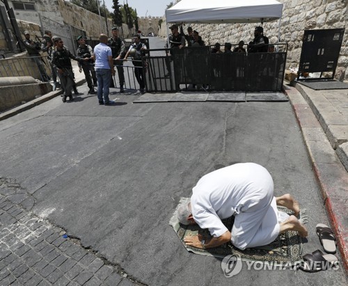 이스라엘이 설치한 검문소 앞에서 기도하는 팔레스타인인. [EPA=연합뉴스]