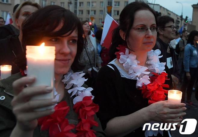 23일(현지시간) 폴란드 시민들이 수도 바르샤바에서 사법독립을 훼손하는 정부의 대법원 개혁안을 규탄하며 촛불 집회를 열었다. © AFP=뉴스1 © AFP=뉴스1