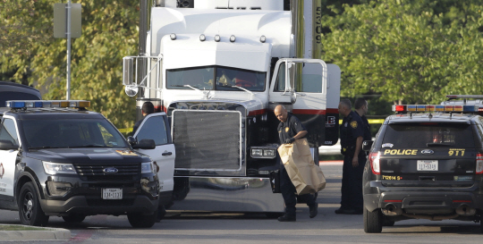 얼마나 뜨거웠을까… : 23일 멕시코 국경 인근에 위치한 미국 텍사스주 샌안토니오에서 경찰들이 불법 이민자로 추정되는 9명이 사망한 트레일러를 수색하고 있다.  AP연합뉴스
