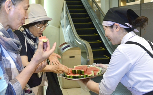 [교도=연합뉴스 자료사진] 일본 백화점 다카시마야 신주쿠점에서 19일 '폭염 서비스'로 시식용 수박을 제공하고 있다.