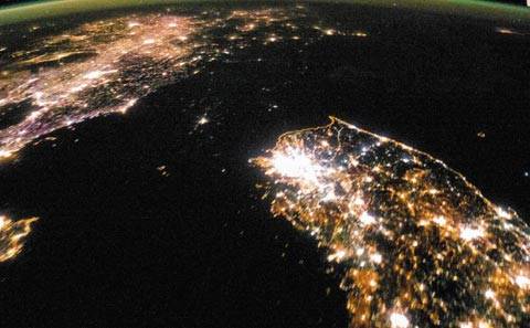 北, 밝아졌다지만… - 지난 2014년 1월 30일 밤, 미국 항공우주국(NASA)이 촬영한 한반도 위성사진 모습. 한국개발연구원(KDI)은 인공위성 자료를 통해 북한 지역의 밝기를 분석한 결과, 2000년 이후 북한 경제가 지속 성장한 것으로 추정된다고 밝혔다. 하지만, 평양 인근을 제외하면 거의 불빛이 보이지 않는 북한과 전 국토가 골고루 밝은 남한 간에는 상당한 차이가 있음을 알 수 있다. /NASA 홈페이지