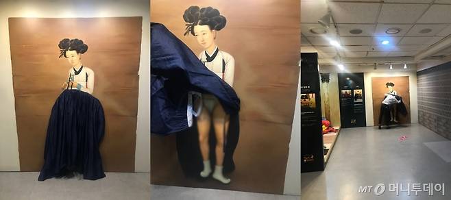 '박물관은 살아있다'에 전시된 신윤복의 미인도, 치마 속을 들춰보라는 입체 체험이다, 한 남성이 치마 속을 보고있다(왼쪽부터)/사진=한지연기자