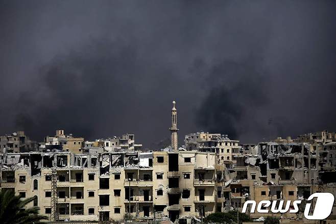14일(현지시간) 시리아 라카 서부 알 다르야 지역에서 공습으로 인한 검은 연기가 피어오르고 있다. © AFP=뉴스1