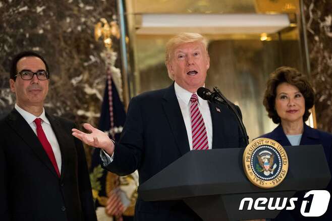 트럼프 대통령이 15일 뉴욕 트럼프타워에서 샬러츠빌 사태 관련 기자회견을 했다. 그 뒤편에는 스티븐 므누신 재무장관과 일레인 차오 교통장관이 자리했다.  © AFP=뉴스1