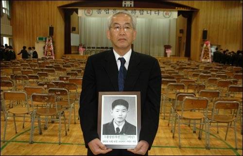 2007년 2월 아들 성인의 영정 사진을 들고 개성중 졸업식을 찾은 홍권식씨. [사진 오마이뉴스]