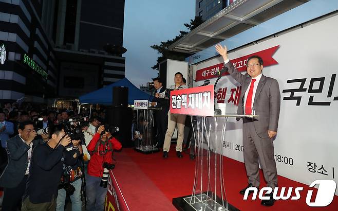 홍준표 자유한국당 대표가 15일 오후 대구 중구 동아쇼핑 앞에서 열린 2차 대국민 보고대회에서 참석자들에게 손을 흔들며 인사하고 있다. 홍 대표는 혁신위원회의 박근혜 전 대통령 자진탈당 권고 발표 이후 이날 처음으로 대구를 방문했다. 2017.9.15/뉴스1 © News1 이종현 기자