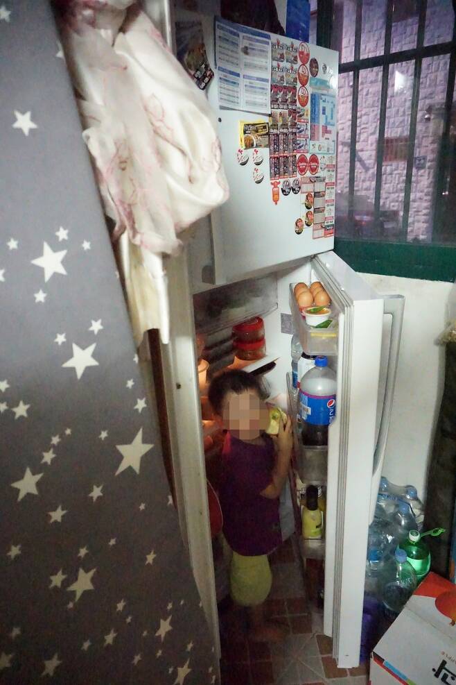 윤성학·권경인씨 부부의 막내 아들이 베란다에 놓인 냉장고 문을 열고 사과를 꺼내 먹고 있다. 박기용 기자