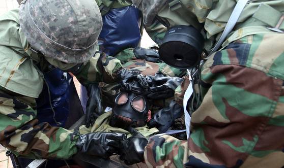 수방사 장병들이 후송된 화학탄 피해 환자의 피복을 제거하고 있다. 박종근 기자