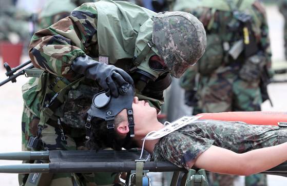 KCAM2 장비를 이용한 잔류 화학물 검사를 마친 수방사 장병이 화학탄 피해 환자의 방독면을 벗겨주고 있다. 박종근 기자