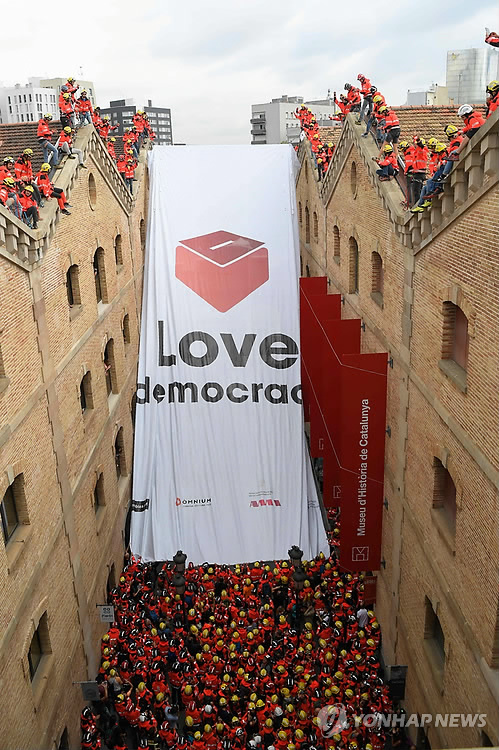 (바르셀로나 AFP=연합뉴스) 카탈루냐 소방관들이 28일(현지시간) 바르셀로나의 카탈루냐역사발문관 앞에 '민주주의를 사랑한다'는 대형 현수막을 걸고 있다.      2016475@yna.co.kr