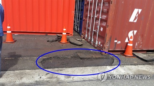 (부산=연합뉴스) '살인 개미'로 불리는 붉은 독개미가 국내에서 처음 발견된 부산항 감만부두 컨테이너 야적장. 언제 반입됐는지 알 수 없는 독개미가 파란색 원 안 아스팔트 아래 공간에 집을 짓고 살다가 발견됐다. 2017.10.2 [부산항만공사 제공=연합뉴스]      wink@yna.co.kr