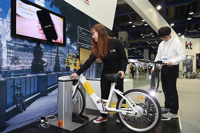 KT부스에 설치된 공용 자전거 관제 서비스 관계자가 무선 충전기 거치대의 전기 자전거 대여 과정을 시연하고 있다. 대여는 QR코드와 칩이 내장된 카드로 가능하며, 실시간 모니터링이 가능하다. 우상조 기자