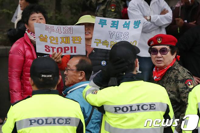 박근혜 전 대통령 지지자들이 13일 오후 박 전 대통령이 롯데·SK로부터 뇌물을 받았다는 혐의에 대한 추가 구속영장이 발부되자 서울 서초구 서울중앙지방법원 앞에서 재판부에 거세게 항의하고 있다. © News1 민경석 기자