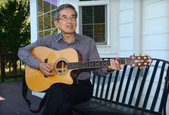 이계호 충남대 명예교수가 충북 옥천 태초 먹거리 학교 앞뜰에서 평소 교회 성가대에서 실력을 다져온 기타를 연주하고 있다.  신창섭 기자