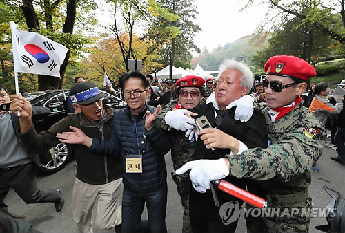 (서울=연합뉴스) 이정훈 기자 = 자유한국당 류석춘 혁신위원장이 26일 오전 서울 동작구 국립서울현충원 박정희 전 대통령 묘역에서 열린 제38주기 추도식에서 박 전 대통령 지지자들에게 쫓겨나고 있다.      uwg806@yna.co.kr