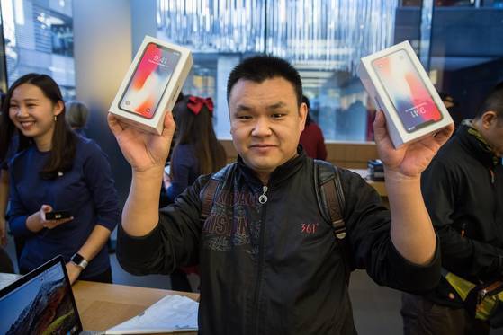 베이징의 애플 매장에서 첫번째로 아이폰X를 구입한 고객이 자신의 아이폰을 들어보이고 있다. [epa=연합뉴스]