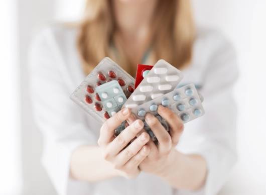 다양한 종류의 약을 든 여성