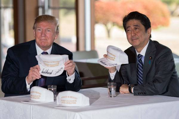 도널드 트럼프 미국 대통령(왼쪽)과 아베 신조(安倍晋三) 일본 총리가 5일 사이타마(埼玉) 현 가스미가세키(霞が關)CC에서 오찬을 하기에 앞서 함께 서명한 모자를 들어 보이고 있다./AFP=연합뉴스