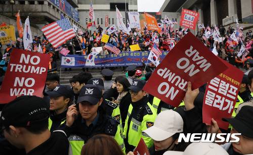 【서울=뉴시스】임태훈 기자 = 도널드 트럼프 미국 대통령이 국빈 방한한 7일 오후 서울 종로구 세종문화회관 앞에서 트럼프 대통령의 방한을 환영하는 시민들 앞으로 방한을 반대하는 손 피켓을 든 대학생들이 지나가고 있다. 2017.11.07. taehoonlim@newsis.com