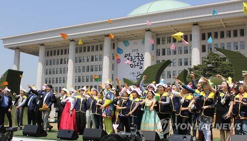 2015년 5월 23일 국회 잔디마당에서 열린 '제10회 국회 동심 한마당'에서 정갑윤 국회부의장을 비롯한 참석자들이 고깔을 쓰고 종이비행기를 날리고 있다. [연합뉴스 자료 사진]