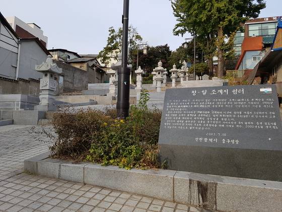 외벽 경관을 일본식으로 꾸민 상가들 옆으로 나 있는 청·일 조계지 쉼터를 알리는 표지석이 있다. [사진 임명수 기자]